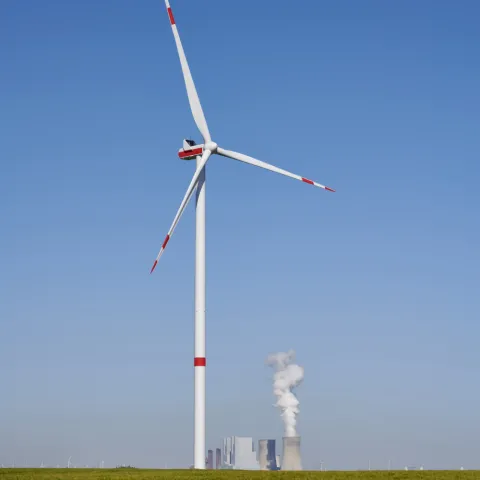 Wind turbine in front of coal power plant.
