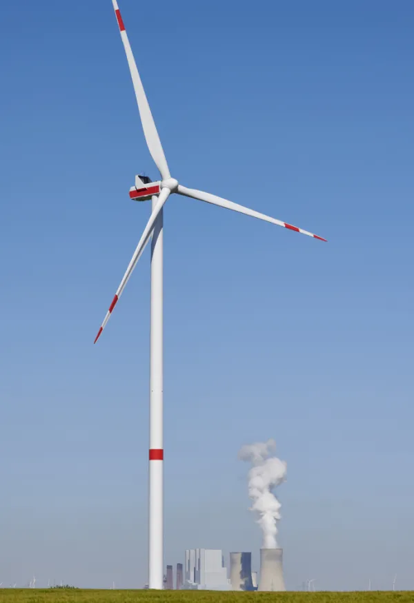 Wind turbine in front of coal power plant.